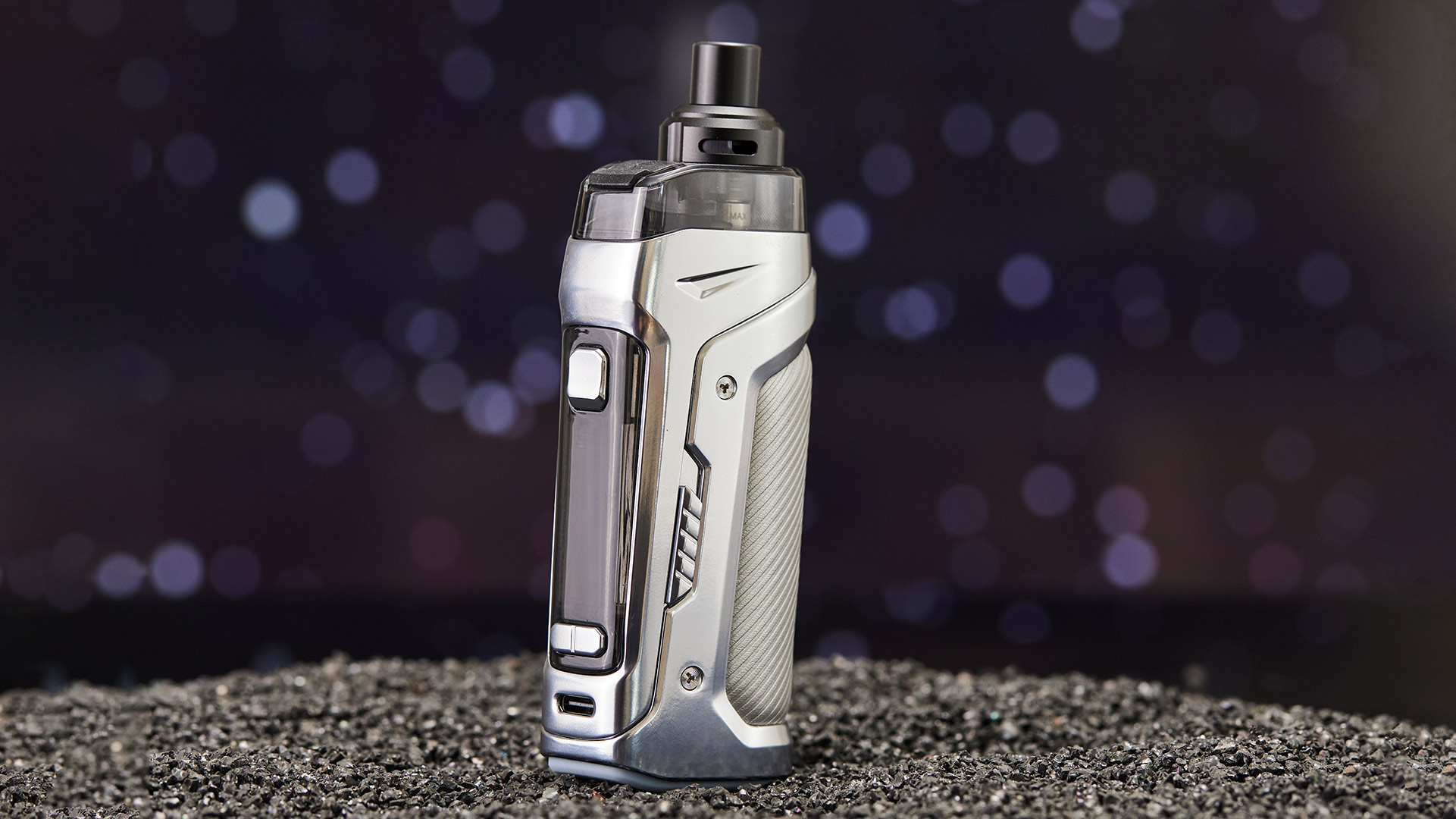 Innokin Coolfire PZPulse pod sigaretta elettronica design elegante color argento, appoggiata su una superficie nera testurizzata con sfondo bokeh.