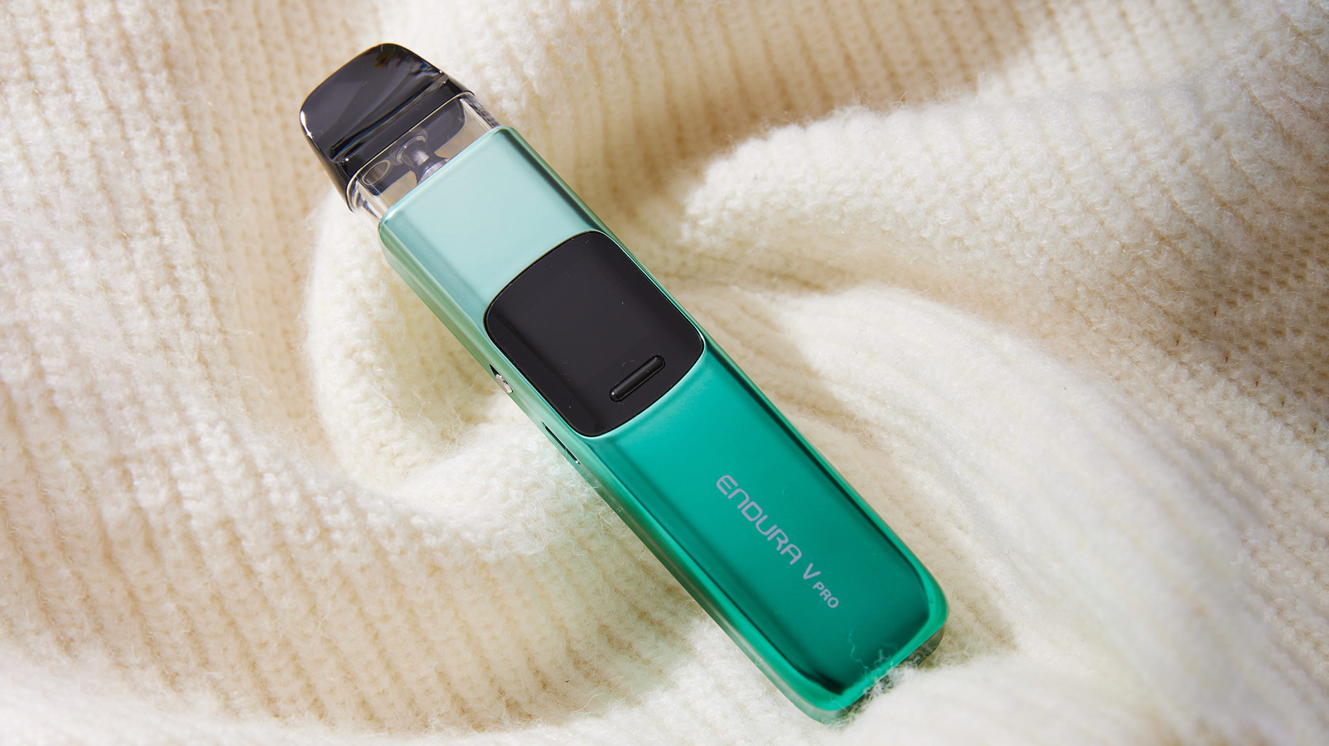 Innokin Endura V pod sigaretta elettronica una vivace finitura verde, appoggiata su uno sfondo di morbido tessuto a maglia.